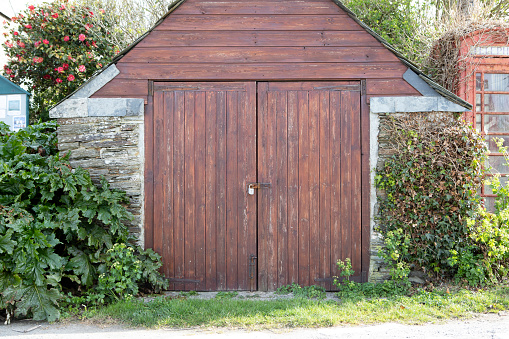 Old abandoned barn with wooden brown gate isolated on white.