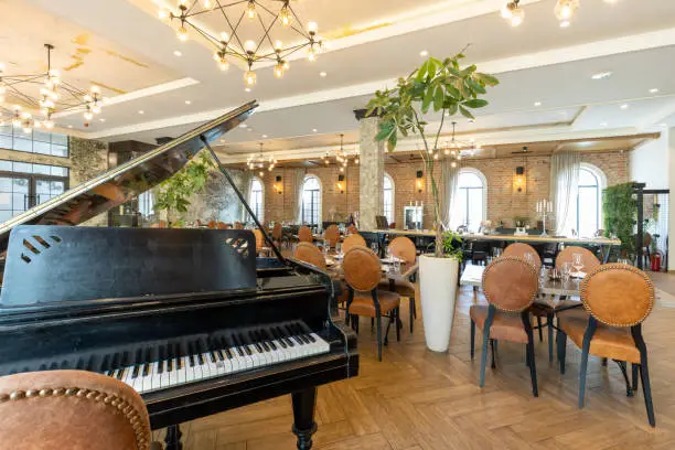 Interior of a modern hotel cafe restaurant with old rustic piano
