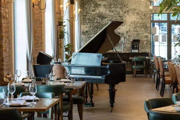 Interior of a modern hotel cafe restaurant with piano