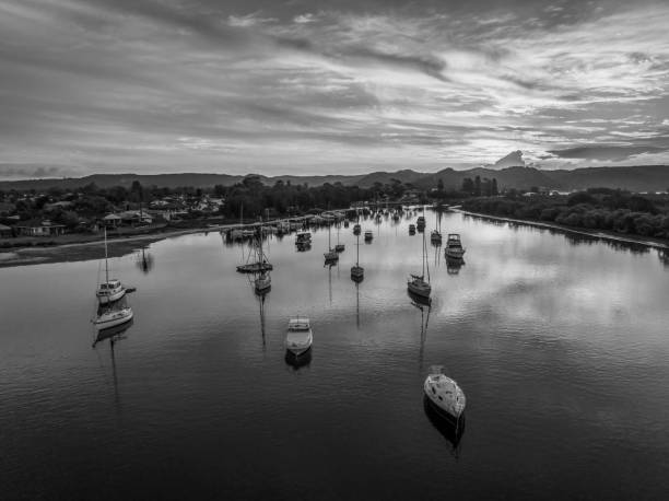Sunset waterscape with boats on the bay in monochrome stock photo