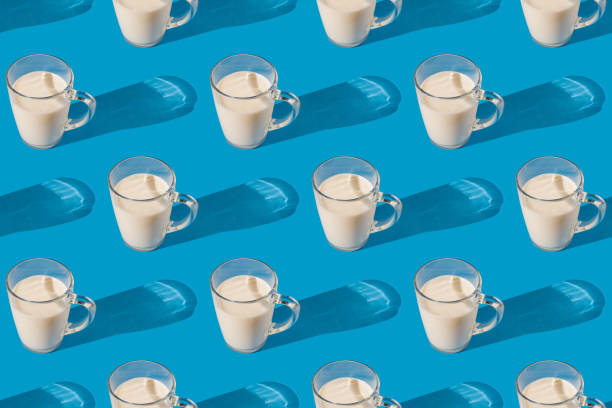 istock Glass mug of fresh milk on a blue background. Repeating seamless pattern 1392282892