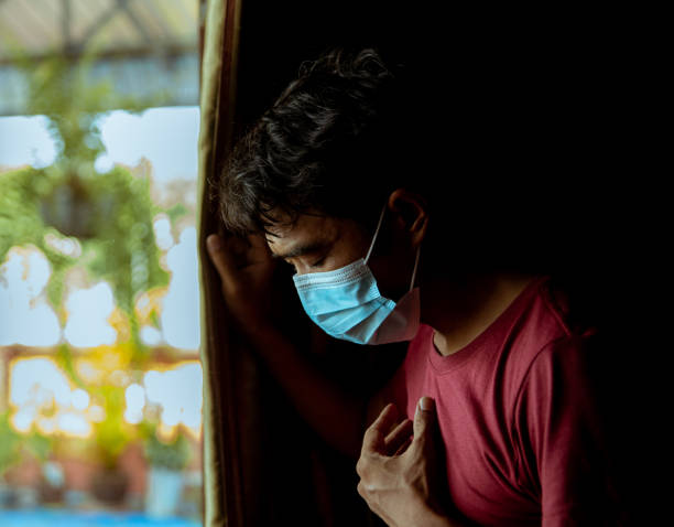 An Asian man wearing a mask has a side effect after suffering from COVID-19. An Asian man wearing a mask has difficulty breathing and has a side effect after suffering from COVID-19. long covid stock pictures, royalty-free photos & images