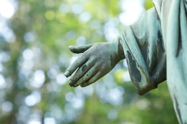 Hand of an old Jesus Christ statue in a cemetery