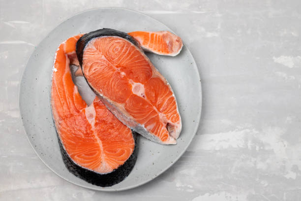 istock raw fresh salmon on ceramic plate with napkin on ceramic 1392284651