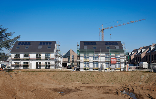 Düsseldorf, Germany - March, 09, 2022: Construction site of two traditional one-family houses with solar panels on the roof in the new housing area of Düsseldorf- Himmelgeist.