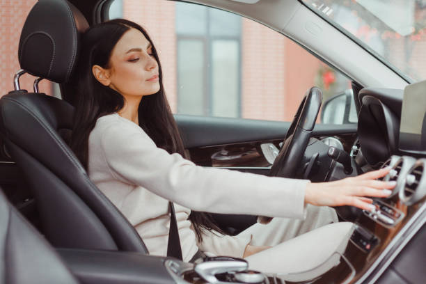 istock Woman turning on car air condition system on dashboard in car panel, Auto car air condition 1392290541