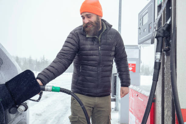 istock A cheerful man refueling during a snowy day. ISL 1392293526