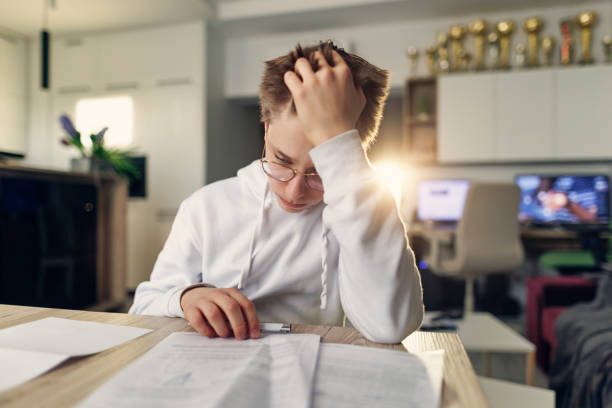 istock Teenage boy doing difficult homework at home 1392295234