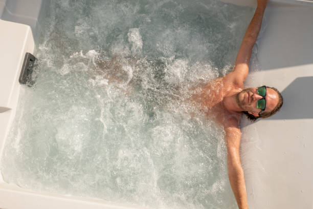 Young man enjoys a spa bath outdoors