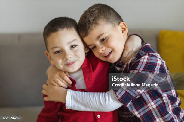 Portrait Of Two Smiling Boys Hugging Stock Photo - Download Image Now - Sibling, Child, Boys