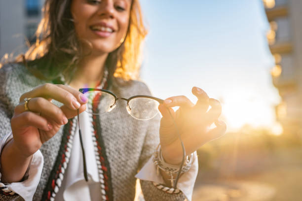 Woman holding eyeglasses stock photo