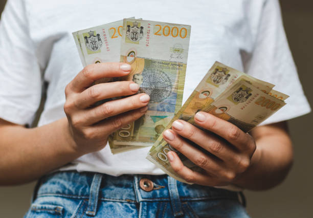 istock Two thousand serbian dinars, money counting banknotes in hands. 1392299102