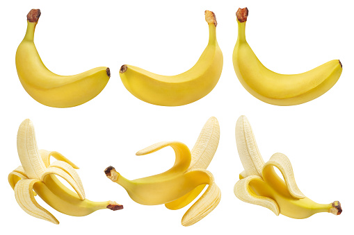 Stock photo showing close-up, elevated view of black plastic crate containing bunches of yellow, ripe bananas on the shelves of a green grocer's aisle in a supermarket.