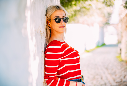 Woman Posing in Front of White Wall in Traditional Aegean Town