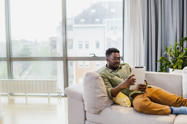 istock African-American man using digital tablet at home 1392301040