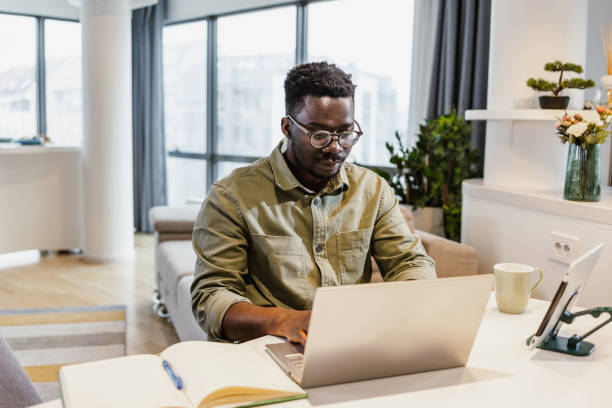 istock African-American man working on laptop at home 1392301041