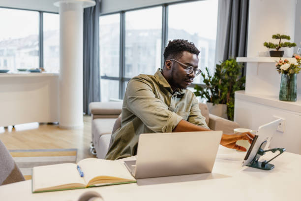 istock African-American man working on laptop at home 1392301095