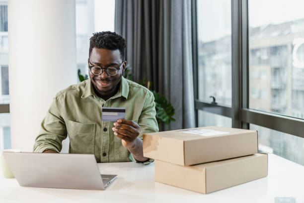 istock Young man using laptop and credit card for e-commerce 1392301576