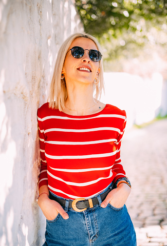 Woman Posing in Front of White Wall in Traditional Aegean Town