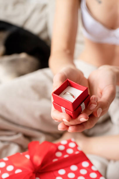 istock Closeup of female hands holding red giftbox with ring 1392301805