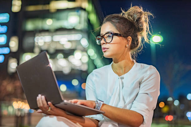 istock Young businesswoman using laptop at night 1392303871