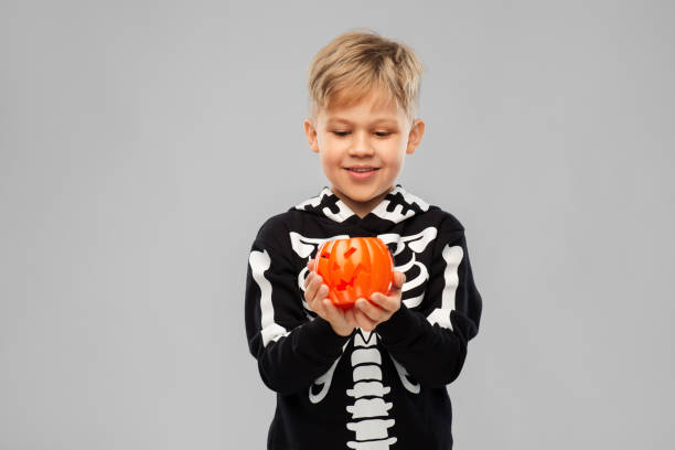 istock happy boy in halloween costume with jack-o-lantern 1392306791