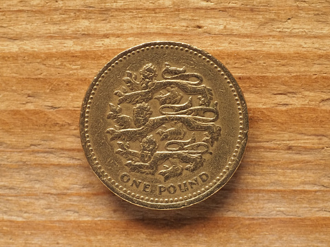one pound coin reverse side showing three lions passant guardant representing England, currency of the United Kingdom