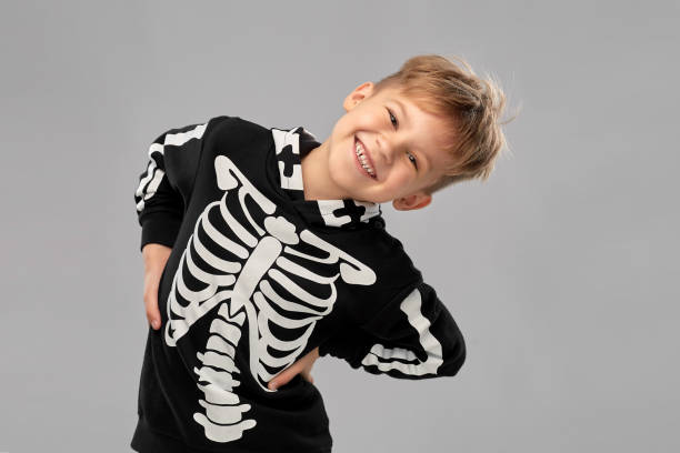 istock boy in black halloween costume with skeleton bones 1392307003
