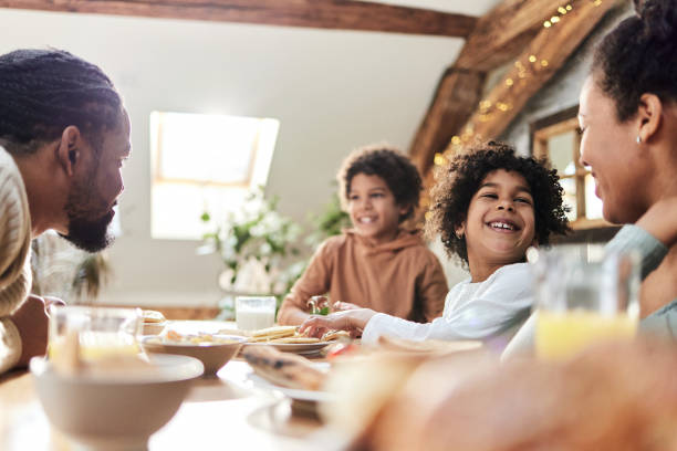 istock Happy black parents and their kids talking during breakfast. 1392307088