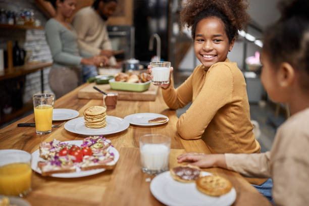 istock Happy African American sisters talking in dining room. 1392307733