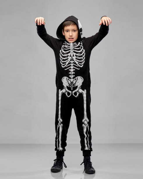 istock boy in halloween costume of skeleton making faces 1392307769
