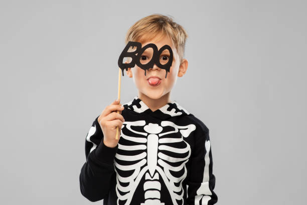 istock boy in halloween costume of skeleton making faces 1392307992