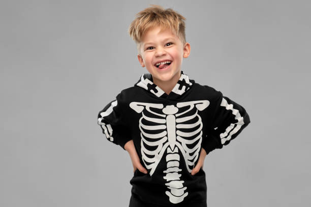 istock boy in black halloween costume with skeleton bones 1392308020