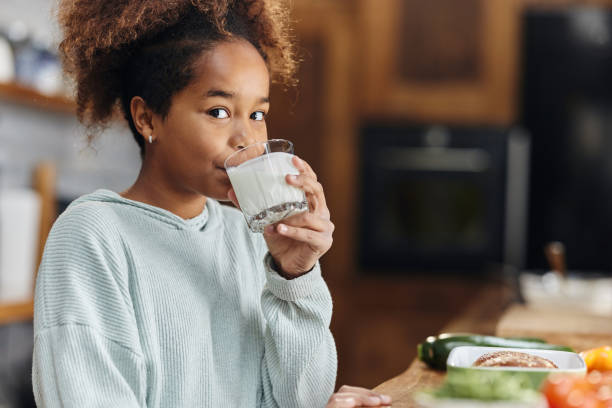 fille afro-américaine buvant du lait le matin. - milk child drinking little girls photos et images de collection