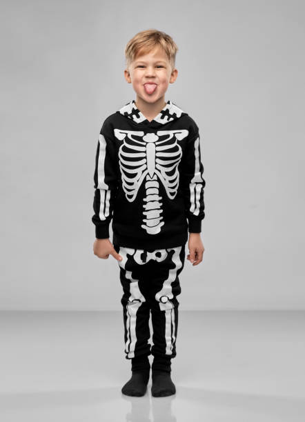 istock boy in black halloween costume with skeleton bones 1392308116
