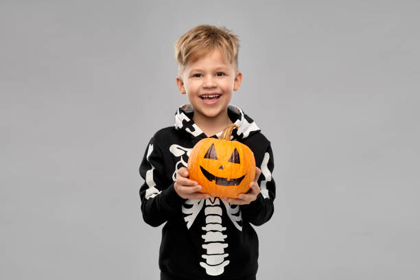 istock happy boy in halloween costume with jack-o-lantern 1392308268