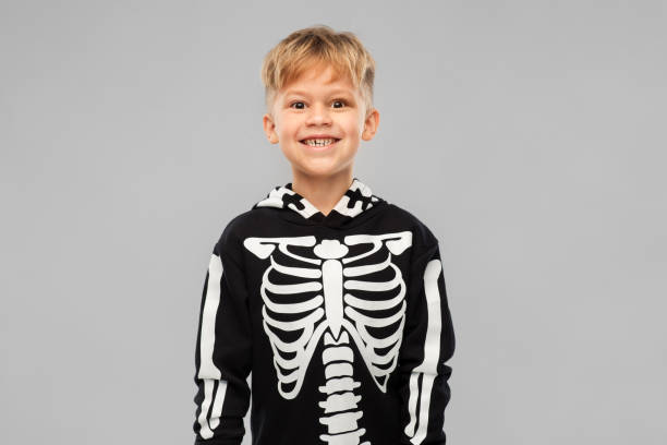 istock boy in black halloween costume with skeleton bones 1392308483