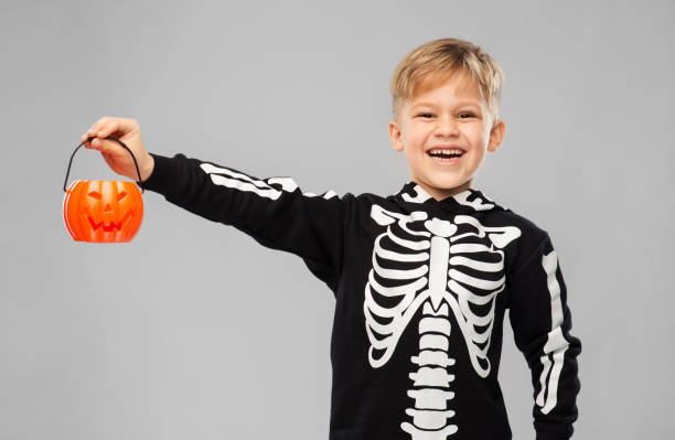 istock happy boy in halloween costume with jack-o-lantern 1392308557