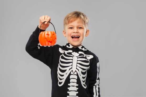 istock happy boy in halloween costume with jack-o-lantern 1392309182