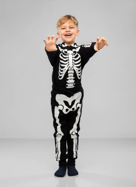 istock boy in halloween costume of skeleton making faces 1392309214