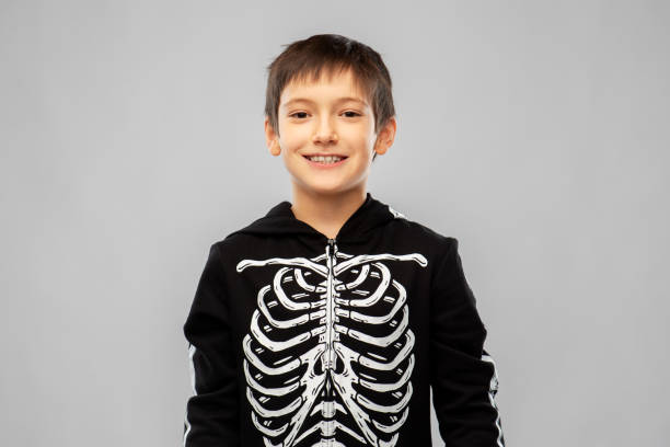 istock boy in black halloween costume with skeleton bones 1392309566