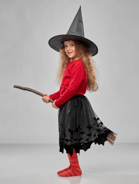 istock girl in black witch hat with broom on halloween 1392309605