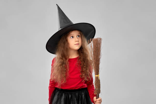 istock girl in black witch hat with broom on halloween 1392309711