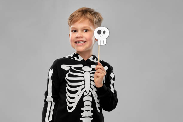boy in halloween costume of skeleton making faces