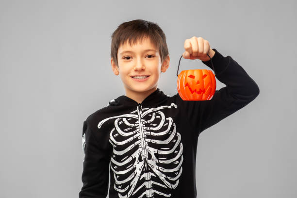 istock boy in halloween costume with jack-o-lantern 1392310142