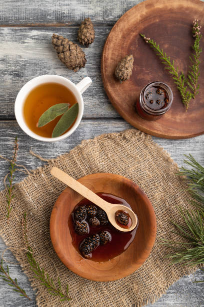 istock Pine cone jam with herbal tea on gray, top view, close up. 1392310219