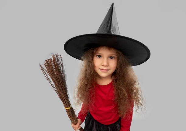 istock girl in black witch hat with broom on halloween 1392310883
