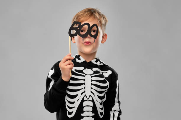 istock boy in halloween costume of skeleton making faces 1392310912