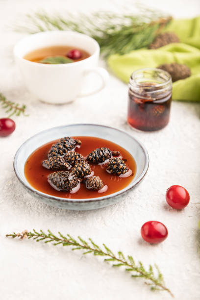 istock Pine cone jam with herbal tea on gray concrete, side view, selective focus. 1392310914