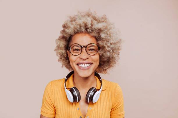 jovem feliz sorrindo mulher afro-americana ouvindo música - neutral look audio - fotografias e filmes do acervo